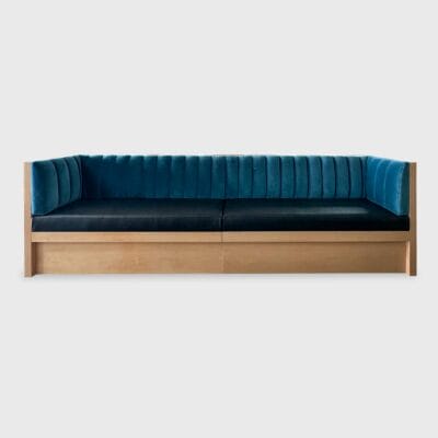 The Augustine Banquette from Jamie Stern features a tight back with vertical channels and recessed wood plinth base.