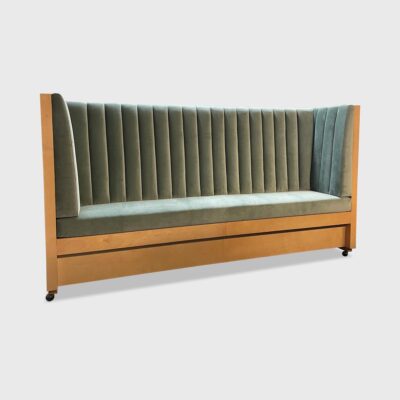 The Augustine Banquette from Jamie Stern features a tight back with vertical channels and recessed wood plinth base.