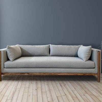 curved back sofa with exposed wood