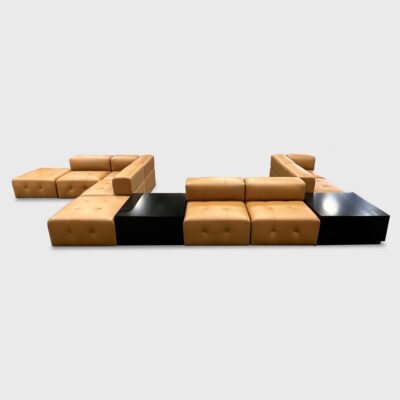 The Bryant Banquette from Jamie Stern features a rounded back, tight seat with button tufting, and wood corner tables.