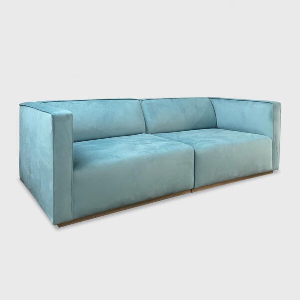 The Damien Sofa from Jamie Stern features a tight back with welt detailing and recessed wood base.
