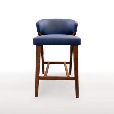 The Lorelei Barstool features a tight seat and back with square tapered legs, a wood "H" stretcher and metal footrest.