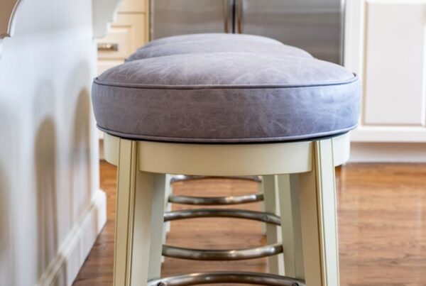 Distressed grey leather upholstered barstools by Jamie Stern