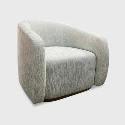 The Nora Lounge Chair from Jamie Stern features a round frame, tight waterfall seat and recessed wood plinth base.