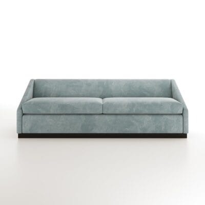 The Roan baby blue sofa from Jamie Stern features dramatically sloped arms and a wood plinth base