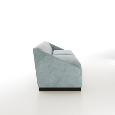 The Roan baby blue sofa from Jamie Stern features dramatically sloped arms and a wood plinth base