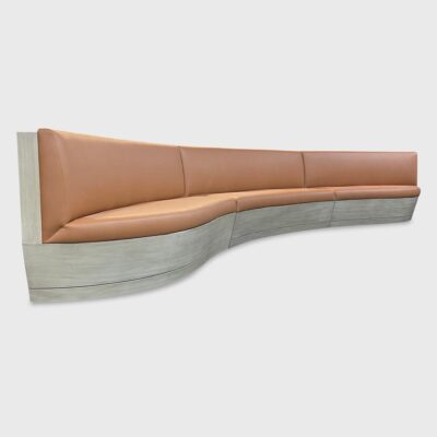 The Warner Banquette features a slight curve, a slanted wood plinth base and tight seat / tight back construction