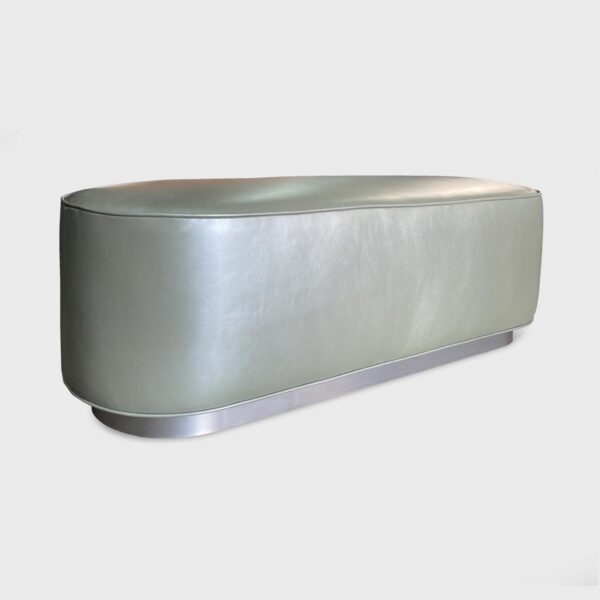 Resting on a metal base, the Whitney Ottoman from Jamie Stern features an upholstered tight seat with welt detailing.